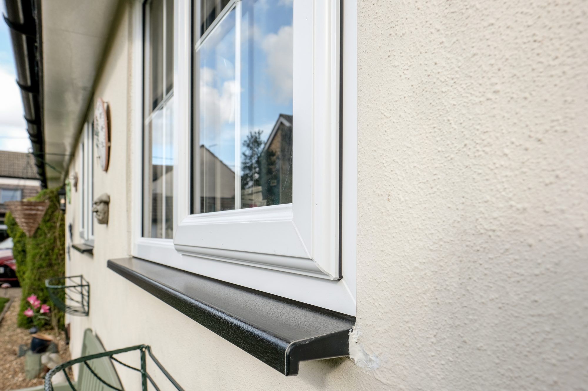 Newly installed, double glazed uPVC windows seen in an home office, seen separate from a distant house.